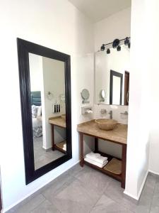 La salle de bains est pourvue d'un grand miroir et d'un lavabo. dans l'établissement Alux, à Bacalar