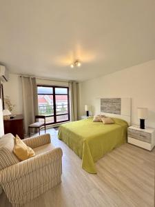 Arriaga Marina Club Apartament في فونشال: غرفة نوم بها سرير وأريكة