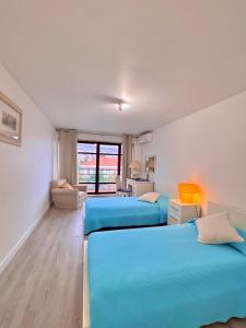 Arriaga Marina Club Apartament في فونشال: غرفة نوم بسريرين ازرق ومطبخ +23 صورة