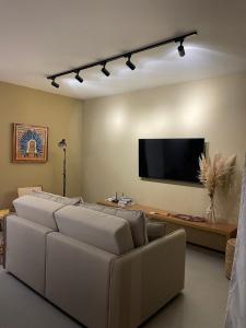a living room with a couch and a flat screen tv at Naay Villas - Flat Beira mar exclusivo in Pôrto de Pedras +33 photos