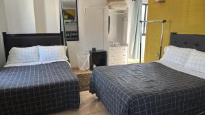 乔卢拉Casa San Andrés的卧室里有两张床、一个梳妆台和一面镜子