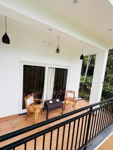 a screened in porch with a table and chairs at Ann Villa homestay in Anachal