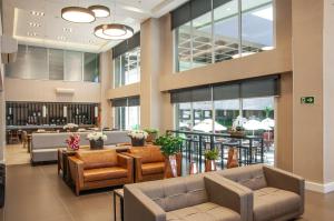 a lobby with couches and chairs in a building at Holiday Inn Express - Farroupilha, um Hotel IHG in Farroupilha