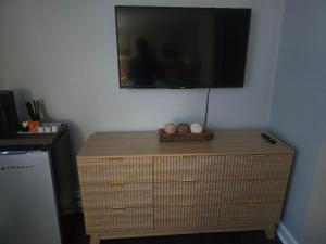 a dresser with a flat screen tv on top of it at Cozy Room in Revere near Beachmont Blue Line Station in Boston +3 photos