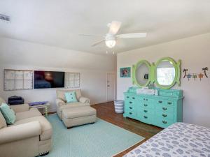um quarto com uma cômoda azul, um sofá e um espelho em Barefoot Children em Tybee Island