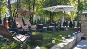 a group of chairs and an umbrella in the grass at Hotel Lo Scoiattolo in Courmayeur