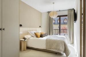a bedroom with a white bed and a window at Cima Panticosa by BeValle in Panticosa