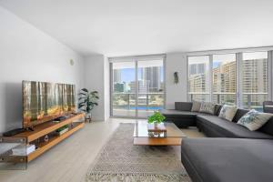 ein Wohnzimmer mit Sofa und Fernseher in der Unterkunft Beach Escape with Balcony & Resort Amenities in Hallandale Beach