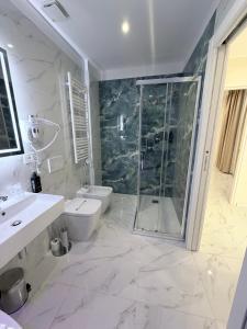 a white bathroom with a shower and a toilet at Hotel Margot in Milan