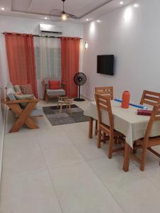 un salon avec une table, des chaises et une télévision dans l'établissement Magnifique Appartement 2 chambres Salon, à Cotonou