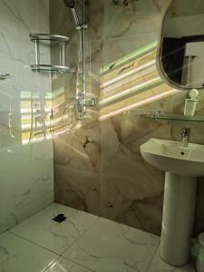 une salle de bain avec un lavabo et un miroir dans l'établissement Magnifique Appartement 2 chambres Salon, à Cotonou