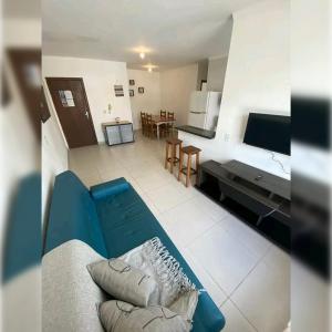 ein Wohnzimmer mit einer blauen Couch und einer Küche in der Unterkunft Hotel Tejas Verdes in Villa Gesell