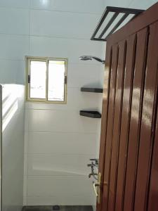 une salle de bain avec une fenêtre et une porte dans l'établissement Magnifique Appartement 2 chambres Salon, à Cotonou