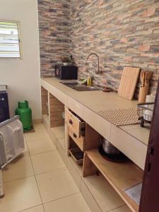 - une cuisine avec un évier et un mur en briques dans l'établissement Magnifique Appartement 2 chambres Salon, à Cotonou 20 autres photos