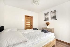 une chambre avec un grand lit avec des draps blancs dans l'établissement Green Point Apartment, Sosnowiec City Center, à Sosnowiec