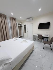 a bedroom with a bed and a desk and a tv at Hotel Margot in Milan