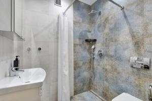 une salle de bain avec douche et lavabo dans l'établissement Green Point Apartment, Sosnowiec City Center, à Sosnowiec