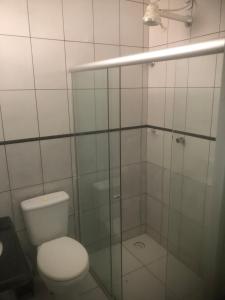 a bathroom with a toilet and a glass shower at Vivenda Hotel in Arapiraca +12 photos