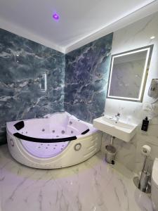 a bathroom with a bath tub and a sink at Hotel Margot in Milan