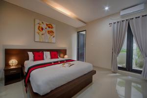 a bedroom with a large bed and a window at Puri Canggu Villas & Rooms in Canggu