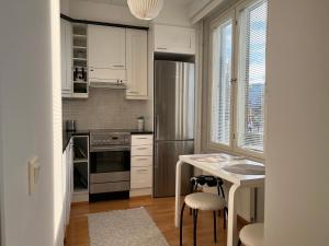eine Küche mit weißen Schränken und einem Edelstahlkühlschrank in der Unterkunft Kaksio järvinäkymällä ja saunalla Lahden Satamasta in Lahti