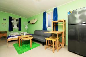 a living room with a couch and a refrigerator at Arya's Surf Camp Cimaja in Sukabumi