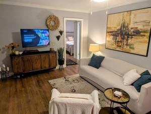 a living room with a white couch and a flat screen tv at Downtown - 2 bed, 1 bath - KC in Raleigh