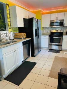 a kitchen with white cabinets and a black refrigerator at Downtown - 2 bed, 1 bath - KC in Raleigh