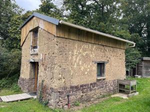 ein Steingebäude mit einem Seitenfenster in der Unterkunft Le petit four à pain in Iffendic