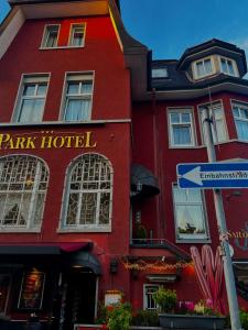 a red hotel with a street sign in front of it at Parkhotel Essen in Essen