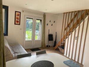 ein Wohnzimmer mit einer Couch und einem Tisch und einer Treppe in der Unterkunft Le petit four à pain in Iffendic