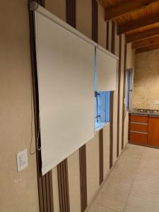 einen großen weißen Bildschirm an einer Wand in einem Zimmer in der Unterkunft Departamentos Negretti in Junín