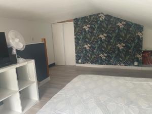 ein Schlafzimmer mit einer Wand mit Blumentapete in der Unterkunft Le petit four à pain in Iffendic