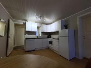 a kitchen with white cabinets and a blue refrigerator at Modern 2 bedroom apartment in the heart of Tromsø in Tromsø +7 photos