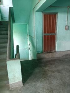 穆扎夫法尔普尔santosh lodge的一间空房间，红色的门，还有楼梯。