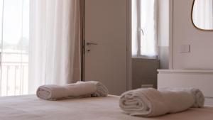 a bedroom with two rolled towels on a bed at White Noise Como in Como