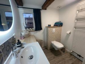 a bathroom with a white sink and a toilet at Cottage A day in Strasbourg in Strasbourg +17 photos