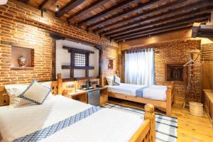 a bedroom with two beds and a brick wall at Sulimha Durbar in Pātan