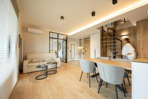 un soggiorno e una sala da pranzo con tavolo e sedie di Marina Ostróda III - widok na jezioro, podziemny garaż, winda, klimatyzacja, wanna i prysznic, 2 łazienki, lux a Ostróda