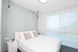 a bedroom with a white bed and a large window at Caesarea :In the front of the sea in Caesarea +25 photos