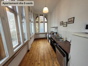 a kitchen with a wooden floor and windows at Forum Sopot in Sopot +22 photos