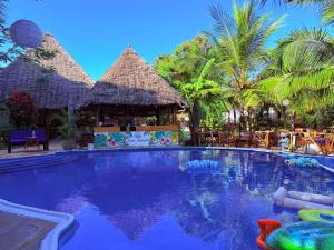 a swimming pool at a resort with palm trees at Oasis Nungwi in Kendwa Mchangani
