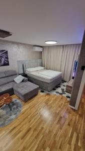 ein Wohnzimmer mit einem Bett und einer Couch in der Unterkunft Premium sunrise in Osijek