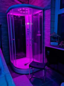 a glass shower with pink lights in a room at Domaine Du Bouleau - Meublé T2 in Bains-les-Bains