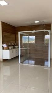 Un baño con ducha de cristal y lavabo. en Cobertura Duplex, en São Lourenço