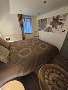 a bedroom with a bed with a painting on the wall at Gîte Vallée de Munster 3 étoiles chez Flavie & Ludo in Muhlbach-sur-Munster