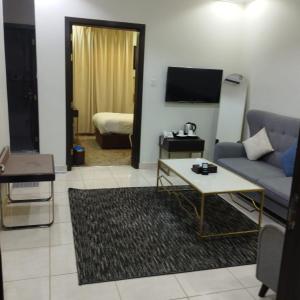 a living room with a couch and a table at شقق ملفا للشقق الفندقية-شقق مخدومة- اقتصادي2 in Nughaylah +14 photos