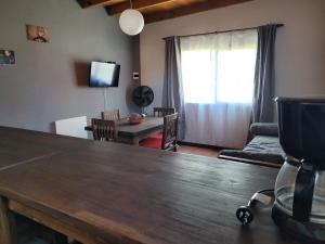 ein Wohnzimmer mit einem Holztisch und einem Esszimmer in der Unterkunft Casas Sigfrid & Max in Camet Norte