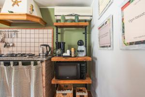 a kitchen with a microwave and a tv on a counter at Ciauru ri Casa in Mascalucia