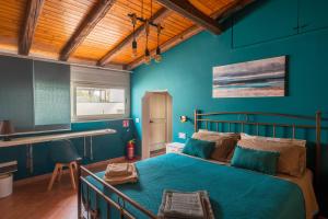 a bedroom with a bed with blue walls and a wooden ceiling at Ciauru ri Casa in Mascalucia +12 photos
